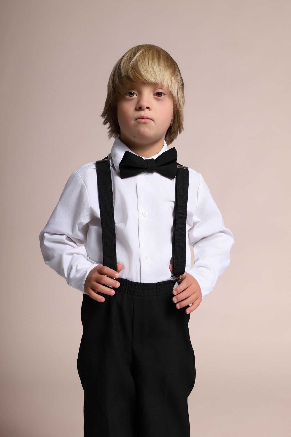 Wesley Wyatt in a white shirt, suspenders, and bow tie, looking into the camera