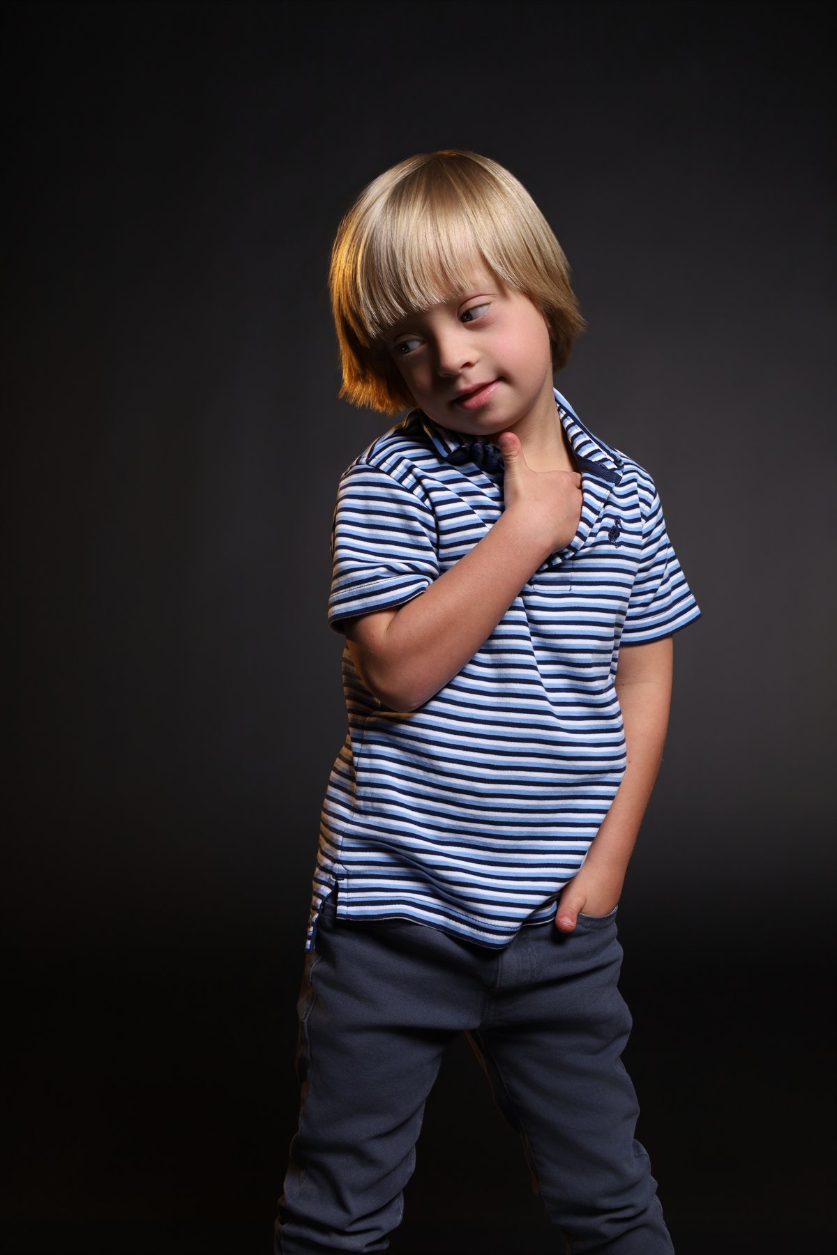 Wesley Wyatt in a striped polo with a hand on his chest, mid-pose