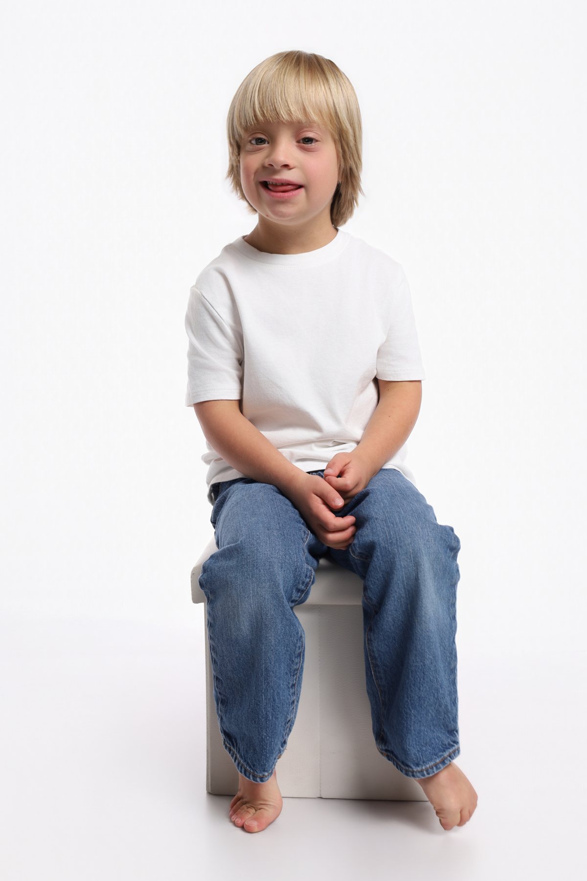Wesley Wyatt seated on a posing block in a white tee, smiling