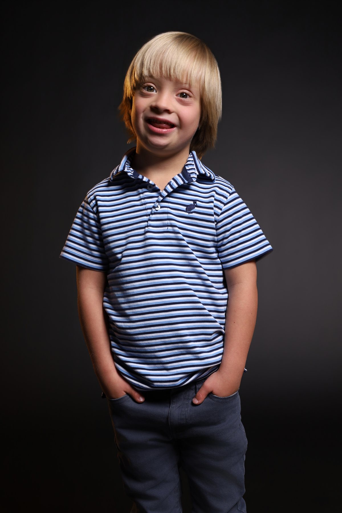 Wesley Wyatt smiling in a striped polo, hands in pockets