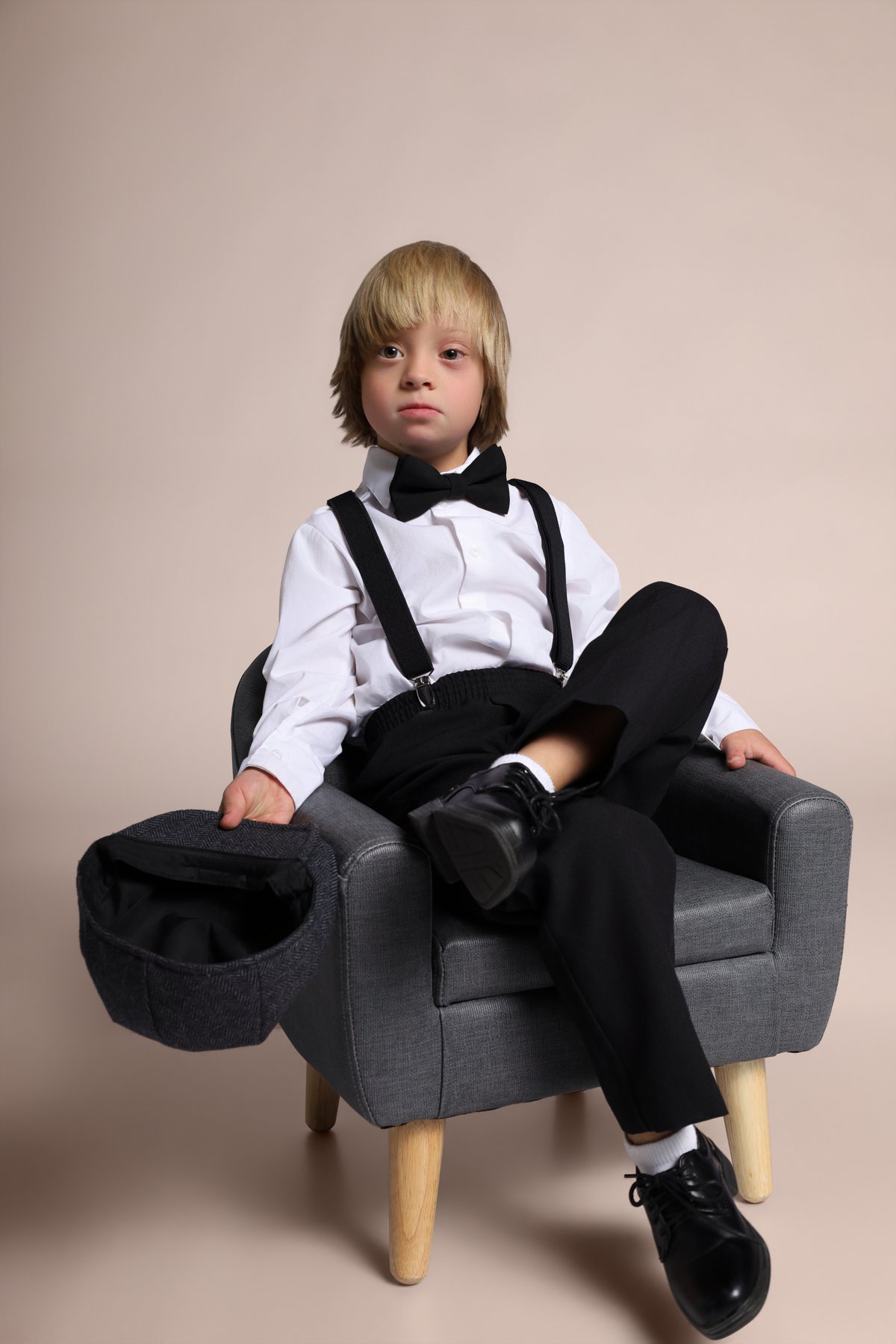 Wesley Wyatt seated in an armchair, cap resting on his knee